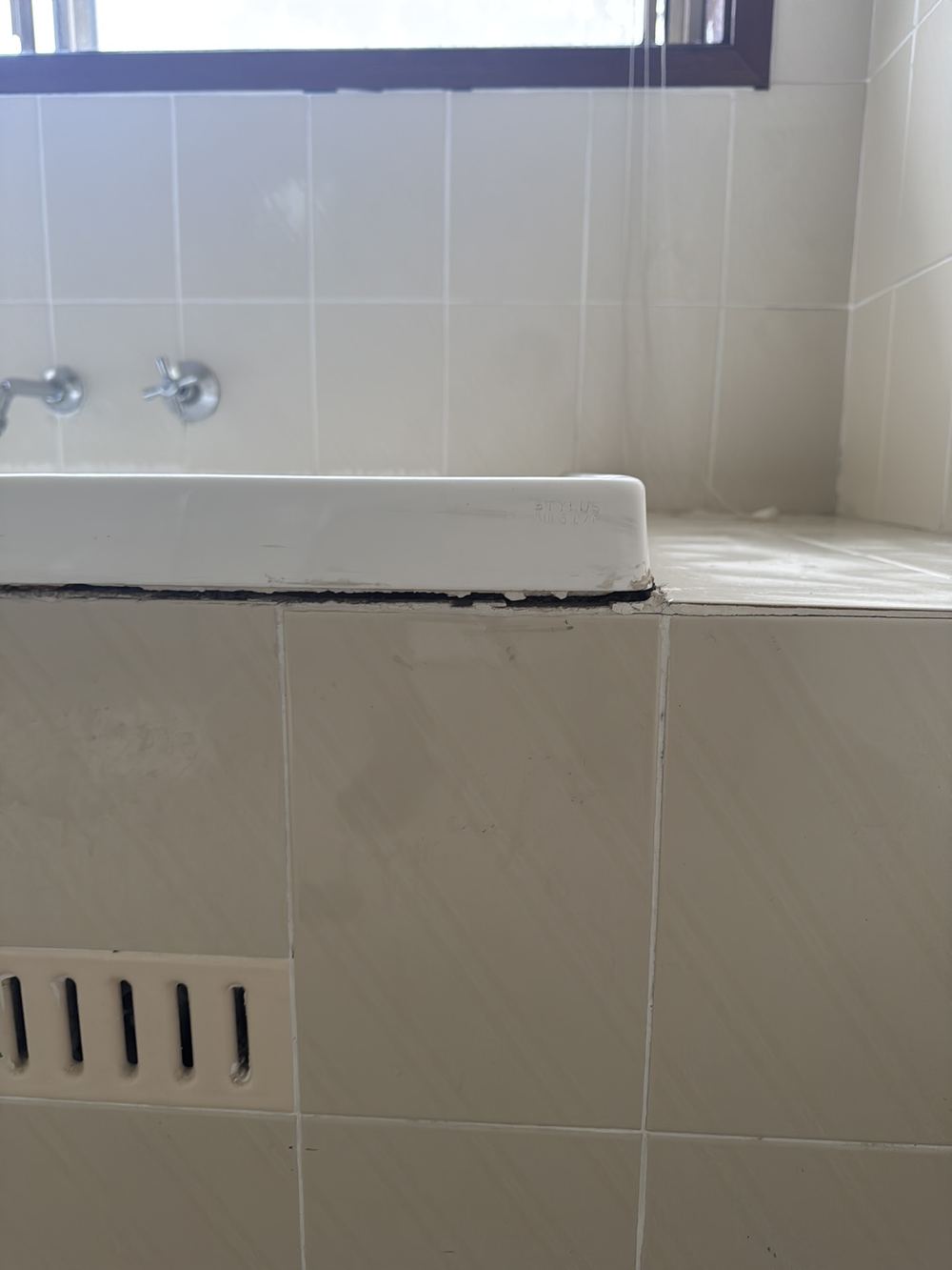 Inbuilt bathtub loose in its frame, straining the plumbing connections, found during a pre-purchase building and pest inspection in Castle Hill